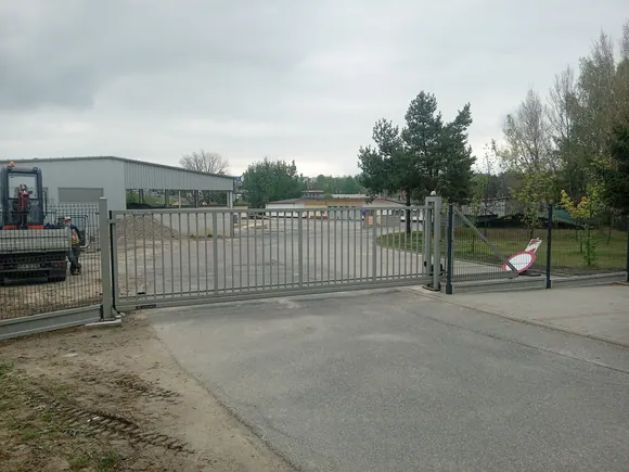 Brama przesuwna przy budynku gospodarczym, widok od strony podjazdu