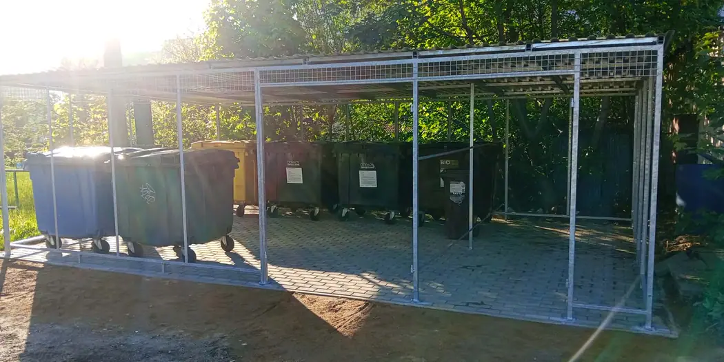 Wiata śmietnikowa z zadaszeniem, w środku pojemniki na odpady
